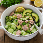 Tuna cucumber salad in a ceramic bowl with avocado and lemon